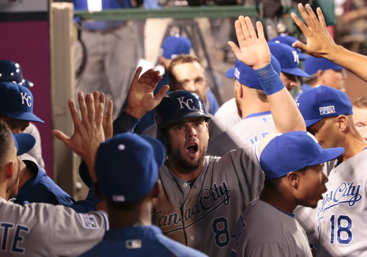 Royals third baseman Mike Moustakas celebrates with teammates after scoring against the Angels in the third inning.