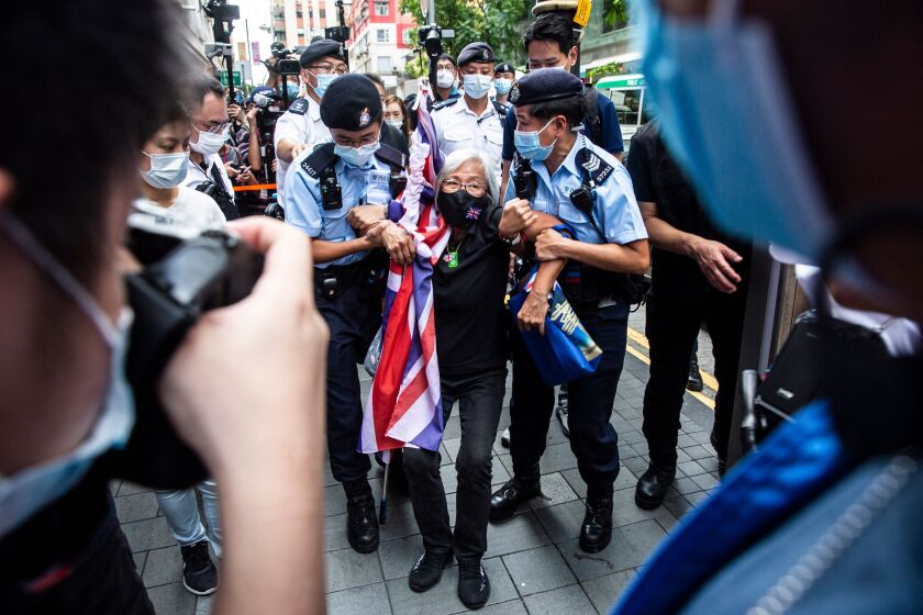 Activist Alexandra Wong is taken away by police while protesting the 24th anniversary of Hong Kong's handover from Britain