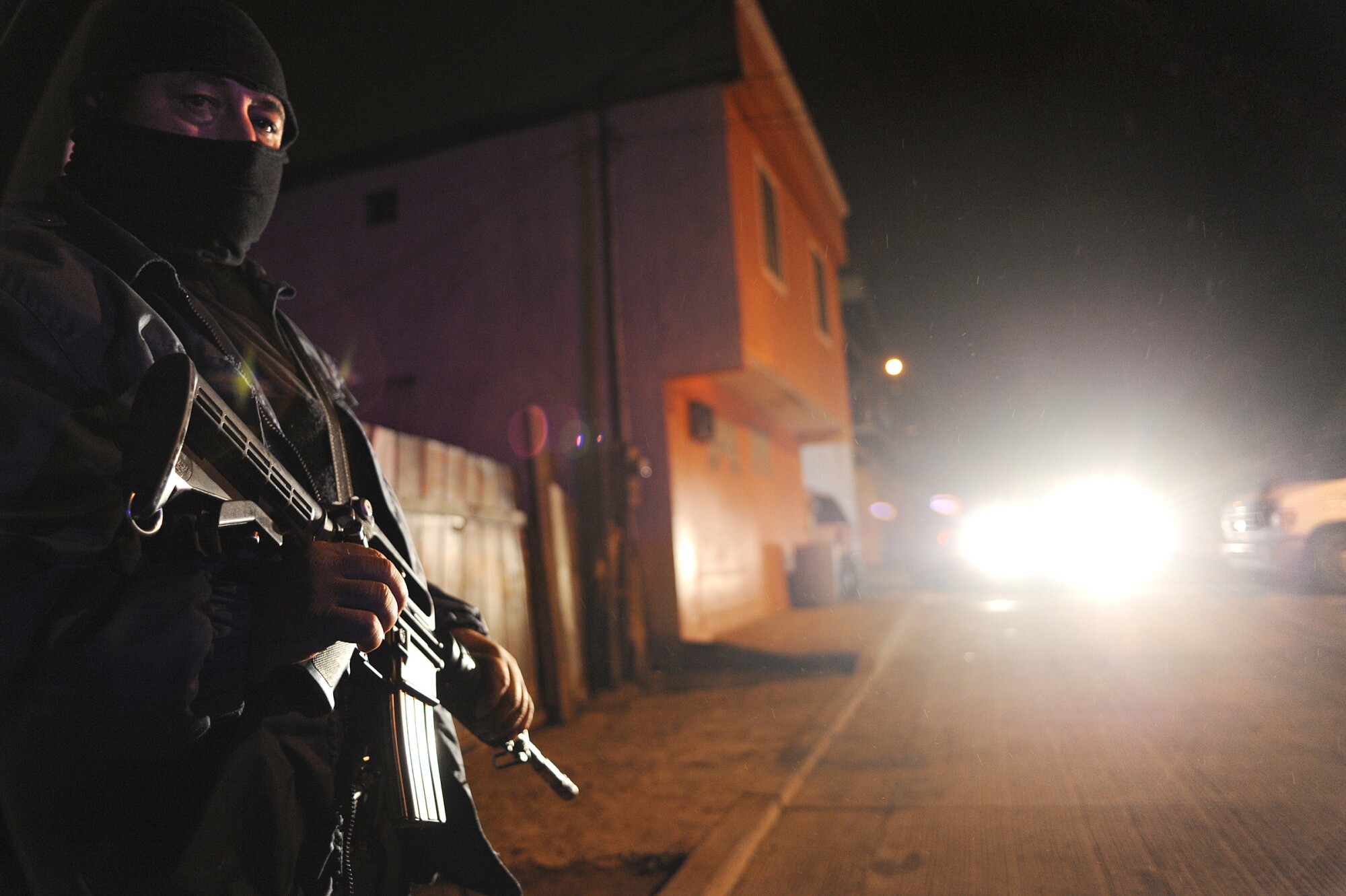 A police officer stands guard outside a drug rehabilitation center where hours earlier gunmen killed 13 people. 