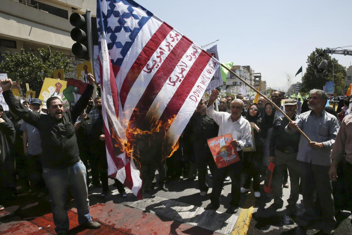 Iranian demonstrators burn a representation of the U.S. flag reading "Down with U.S.A.," in Arabic and Persian during an annual pro-Palestinian rally Friday marking Quds Day in Tehran.