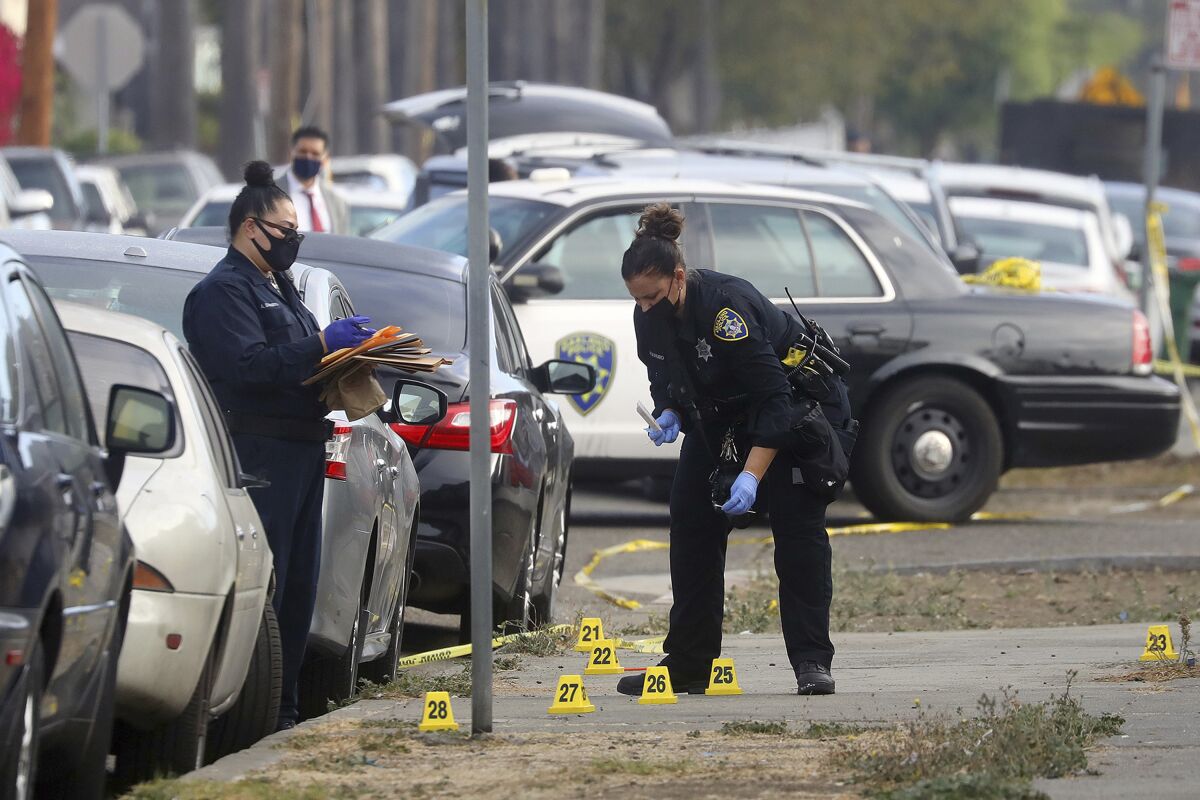 Members of the Oakland Police Department investigate the scene of an officer involved shooting on Wednesday, Nov. 4, 2020, in Oakland, Calif. Police say at least two police officers were injured and a person was shot by police during a robbery at a marijuana business. (Aric Crabb/Bay Area News Group via AP)
