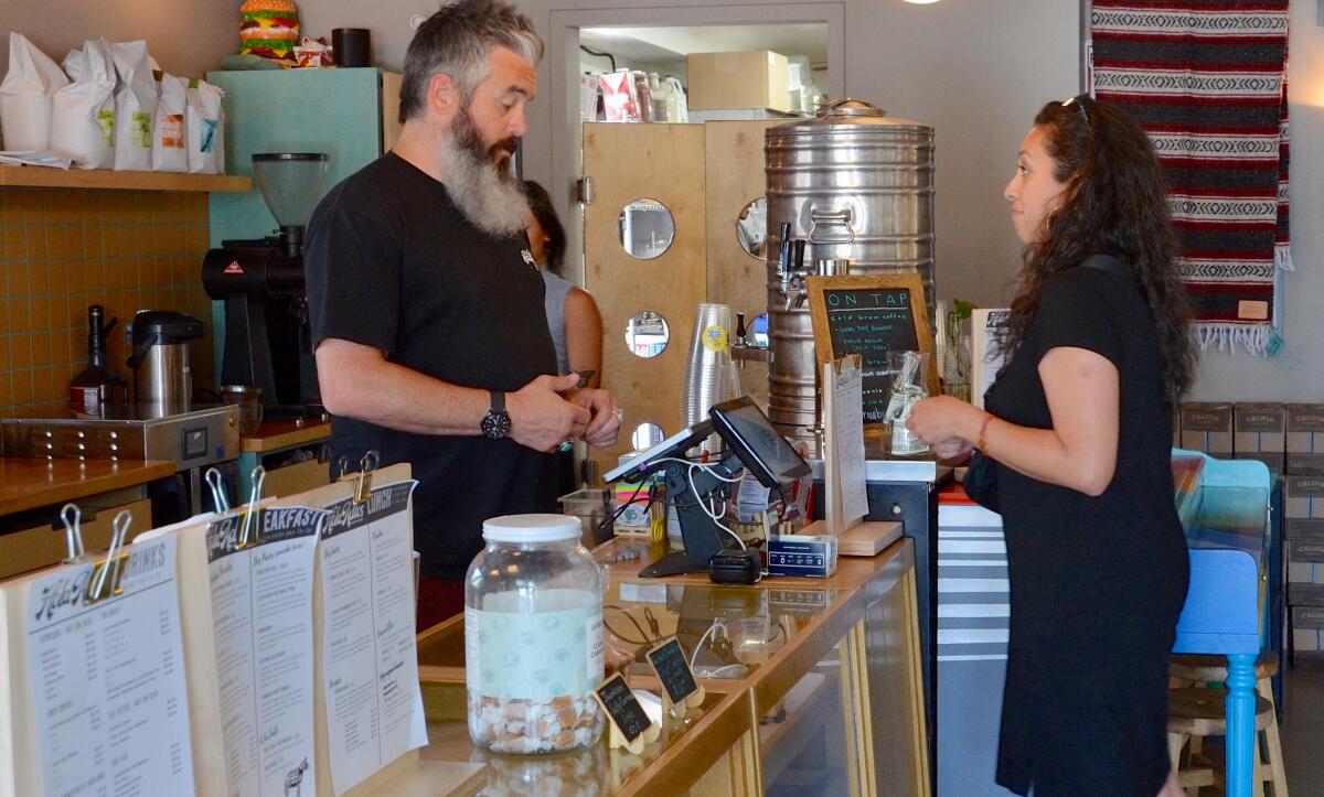 Ryan Jimenez takes a customer's order at Hola Adios Coffeeshop in Costa Mesa.