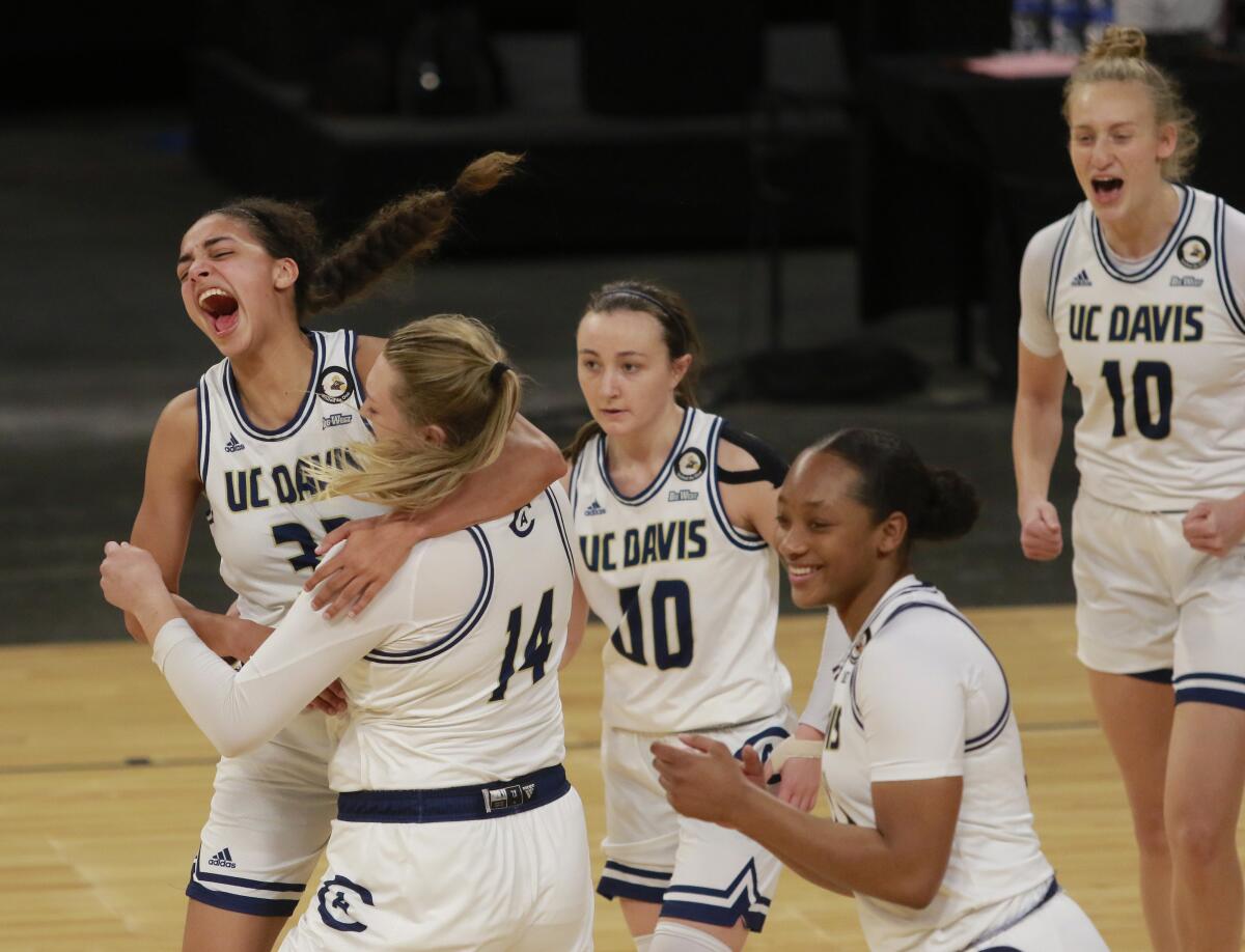 UC Davis' Cierra Hall (32), far left, celebrates with teammate UC Davis' Emma Gibb (14) after they won an NCAA college basketball game against UC Irvine in the championship of the Big West Conference tournament Saturday, March 13, 2021, in Las Vegas. (AP Photo/Ronda Churchill)