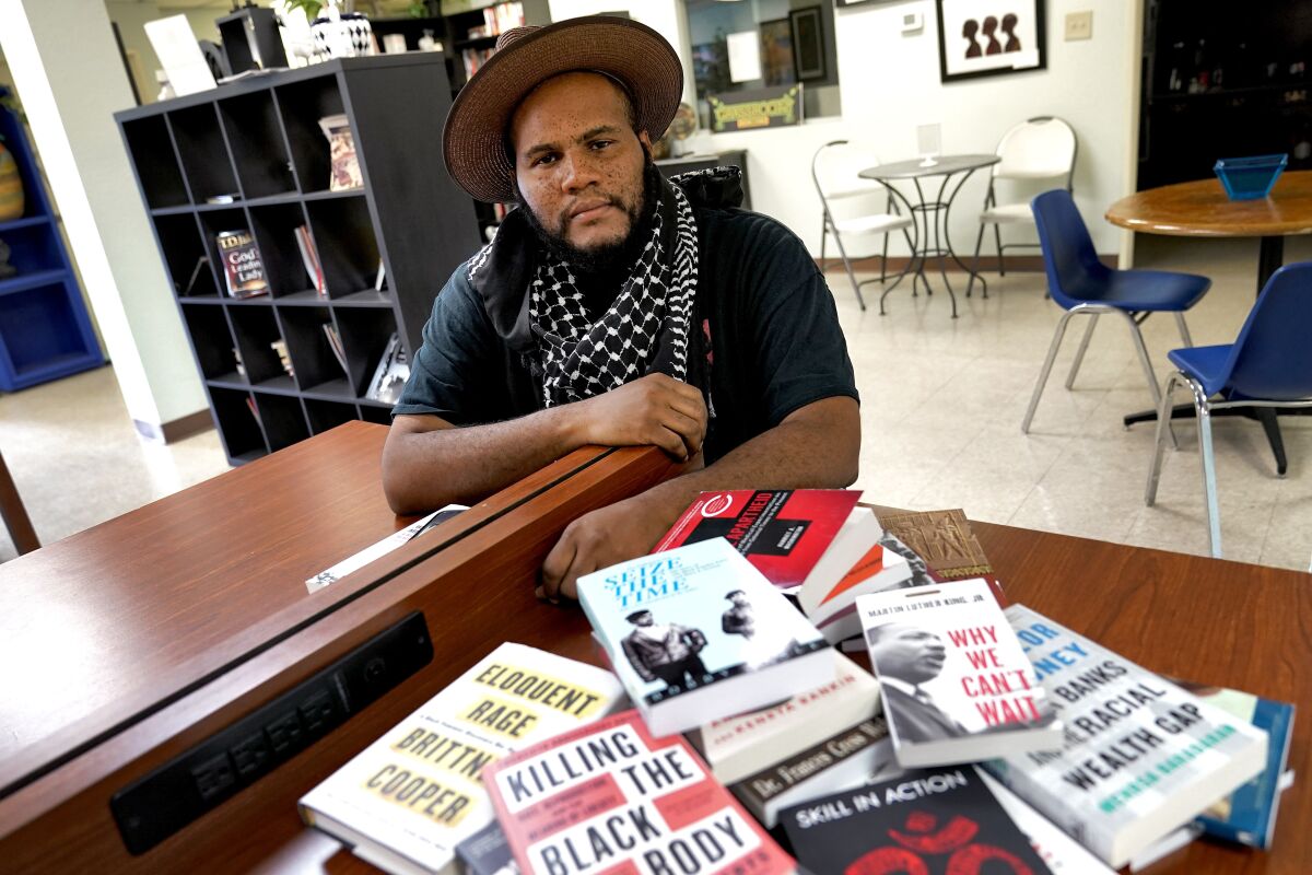 Owner Ali Nervis displays books on race relations at his bookstore in Phoenix