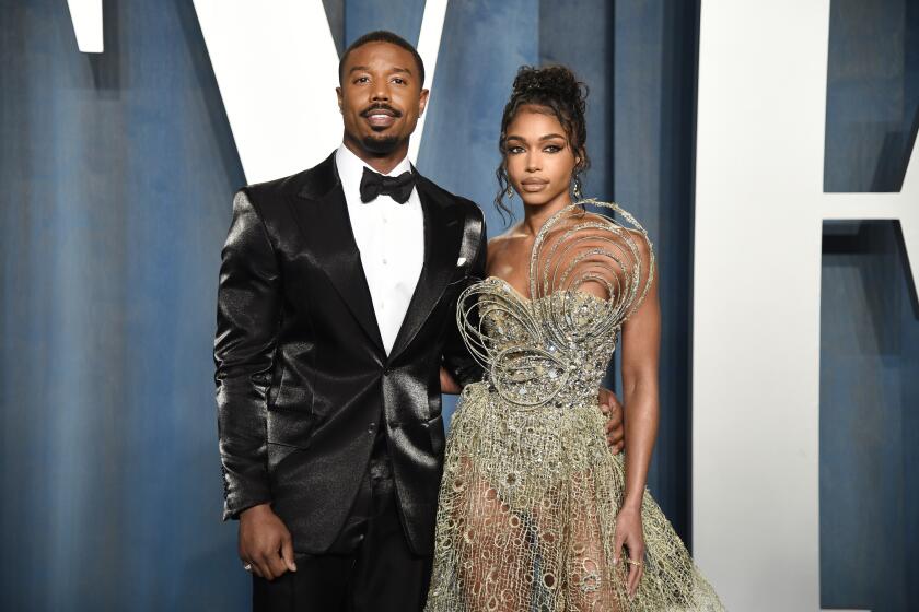 A man in a tuxedo put his arm around a woman in a strapless evening gown