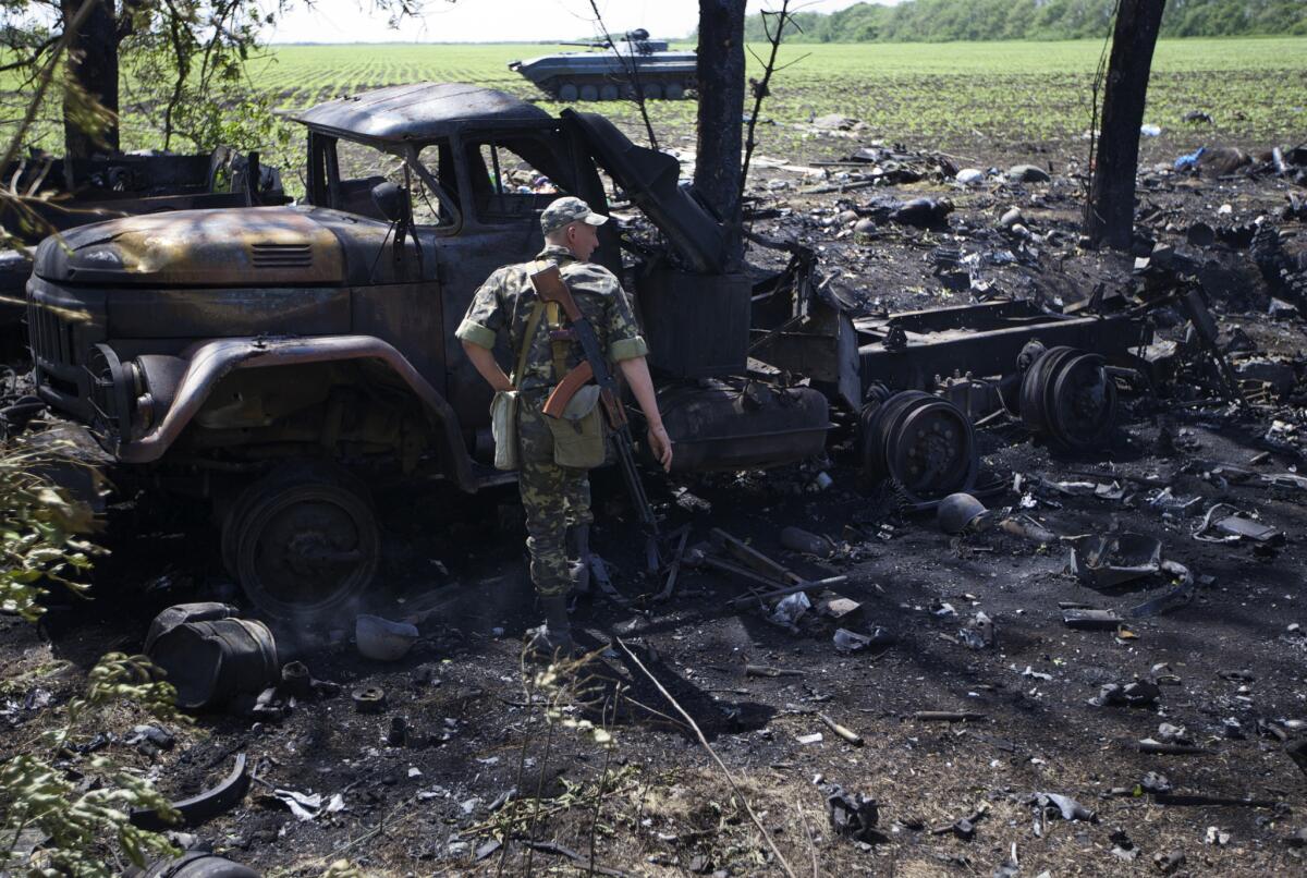 A Ukrainian soldier surveys the charred aftermath of a gunfight site near the village of Blahodatne, in eastern Ukraine. The Kiev government said at least 13 soldiers died in the attack May 22 by pro-Russia separatists, the worst since fighting began in the area more than two months ago.