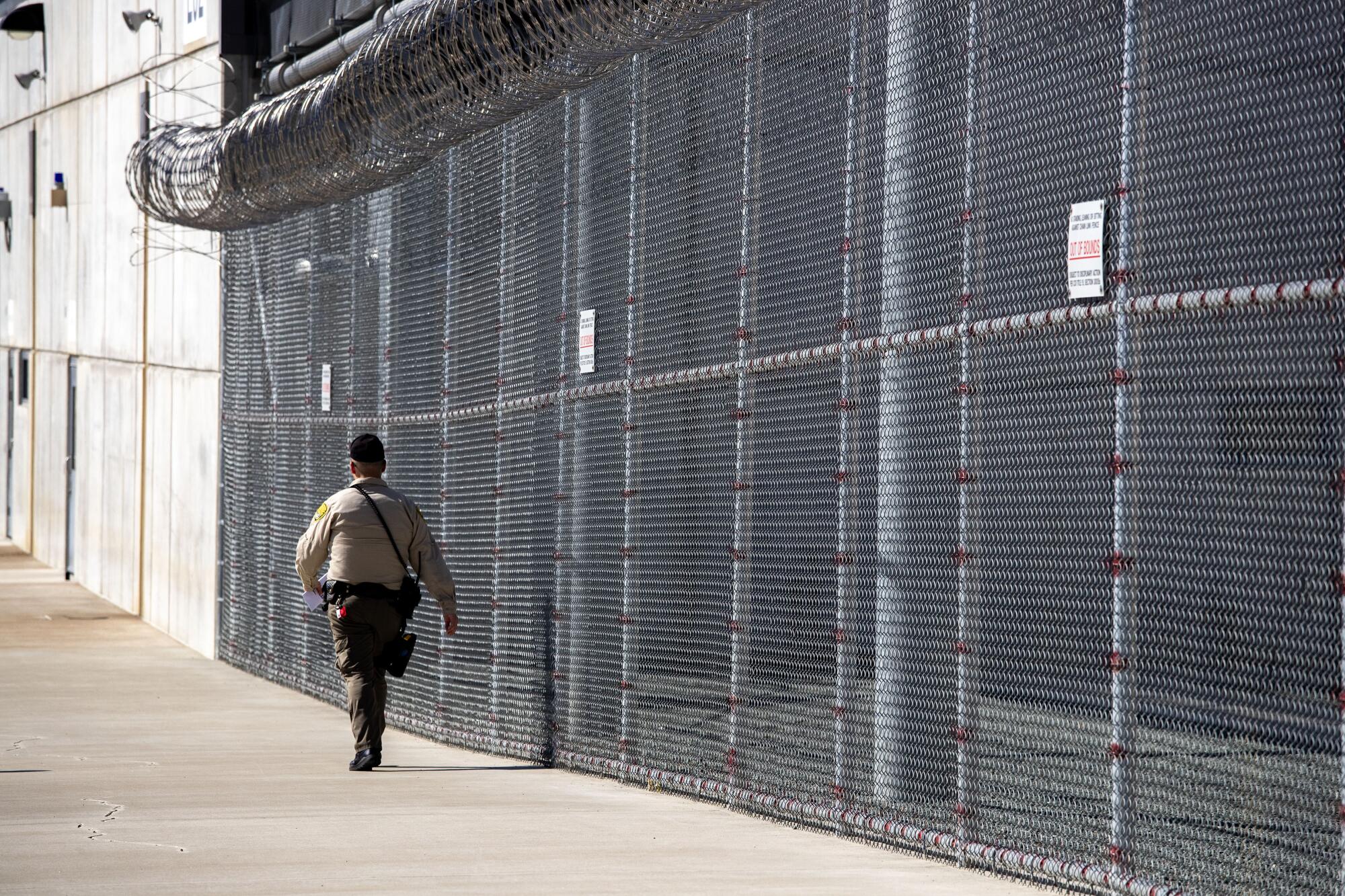 A guard walks inside the perimeter of Mule Creek State Prison in Ione, Calif.
