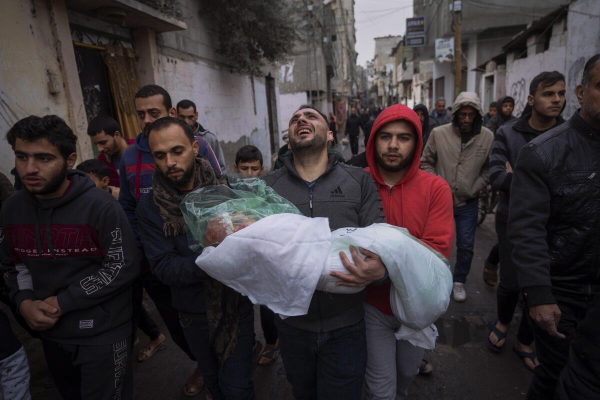 Mohammad Shouman carga con el cadáver de su hija Masa, que murió en un bombardeo israelí 
