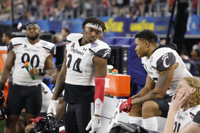 Cincinnati's Jerome Ford (24) talks with Devin Hightower during the second half the Cotton Bowl NCAA College Football Playoff semifinal game against Alabama, Friday, Dec. 31, 2021, in Arlington, Texas. Alabama won 27-6. (AP Photo/Michael Ainsworth)