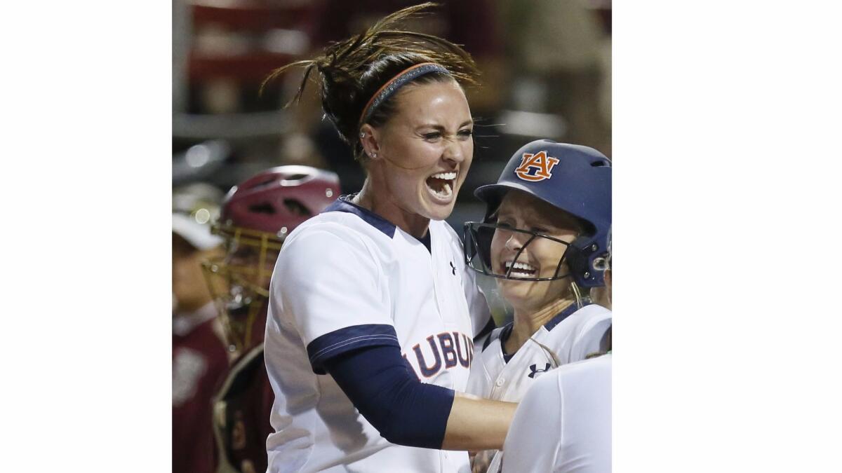 In this June 5, 2016, file photo, Auburn infielder Haley Fagan, left, and outfielder Morgan Podany celebrate Podany's game winning run against Florida State in Oklahoma City.