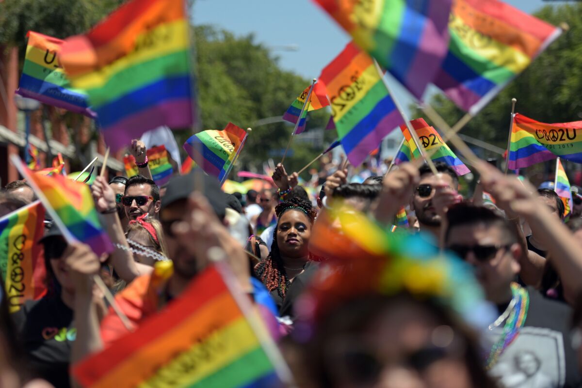 People wave Pride flags during the annual LA Pride Parade in West Hollywood.