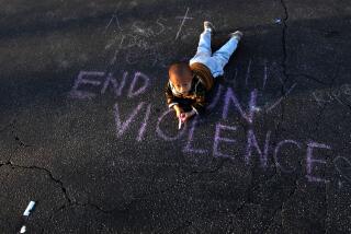Harry Su, 2, lays on the message, "End Gun Violence," at the memorial outside the Star Ballroom Dance Studio