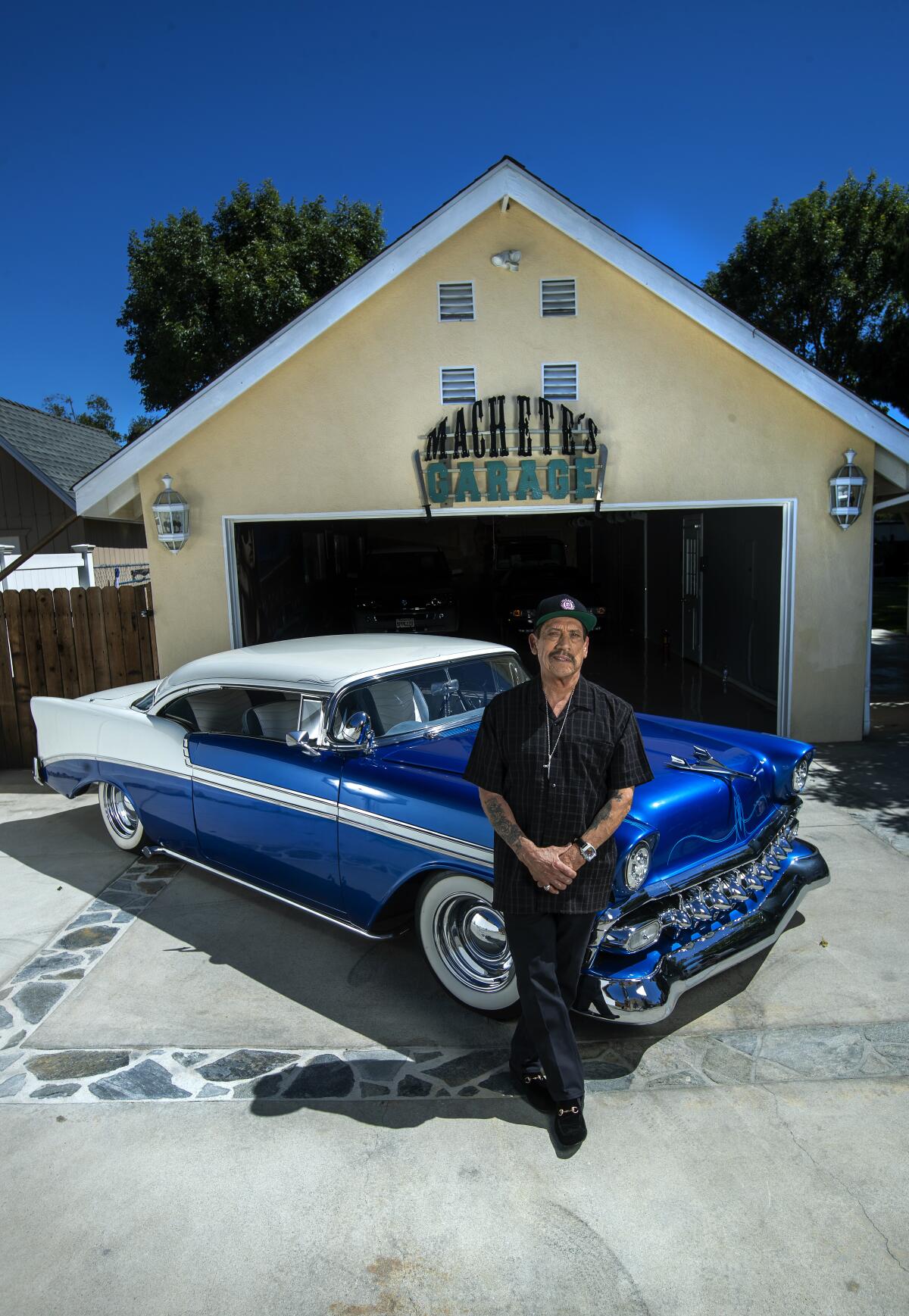 Danny Trejo next to his blue 1956 Chevrolet Bel Air 