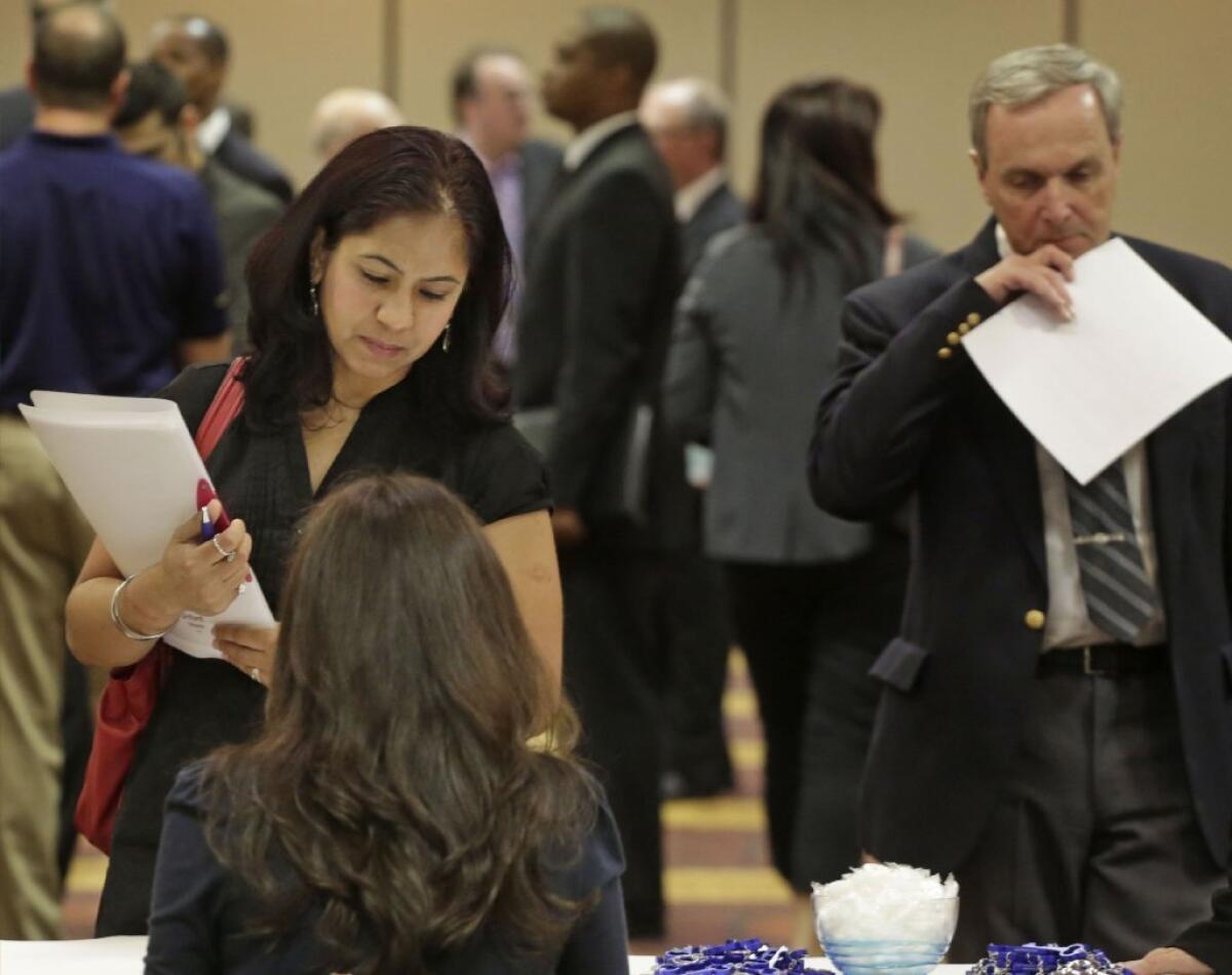 Job seeker Anu Vatal of Chicago speaks with a recruiter during a career fair in Rolling Meadows, Ill.
