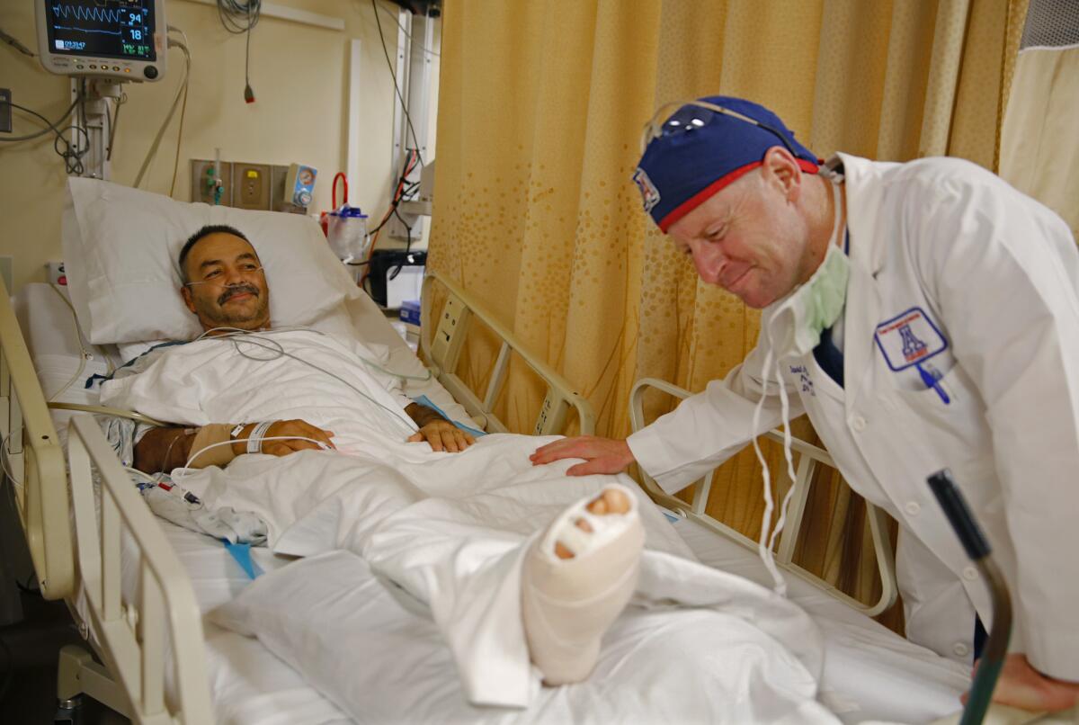 Dr. David Armstrong reassures Jesus Duarte that his foot surgery went well at the University of Arizona Medical Center. Arizona is among 30 states that have expanded their Medicaid programs under the Affordable Care Act.