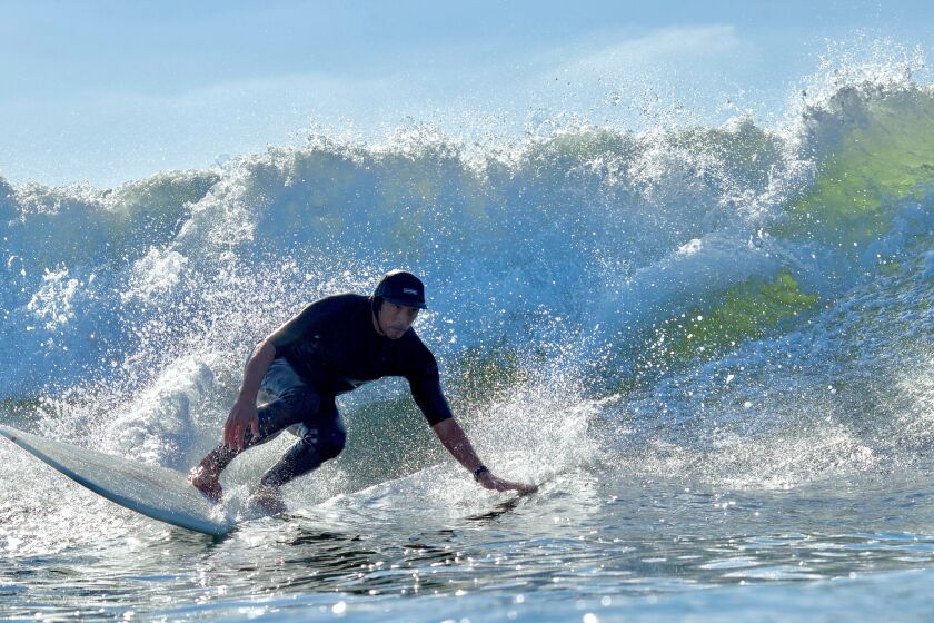 Point Loma Nazarene professor Ben Cater surfs in front of the university along Sunset Cliffs this fall.