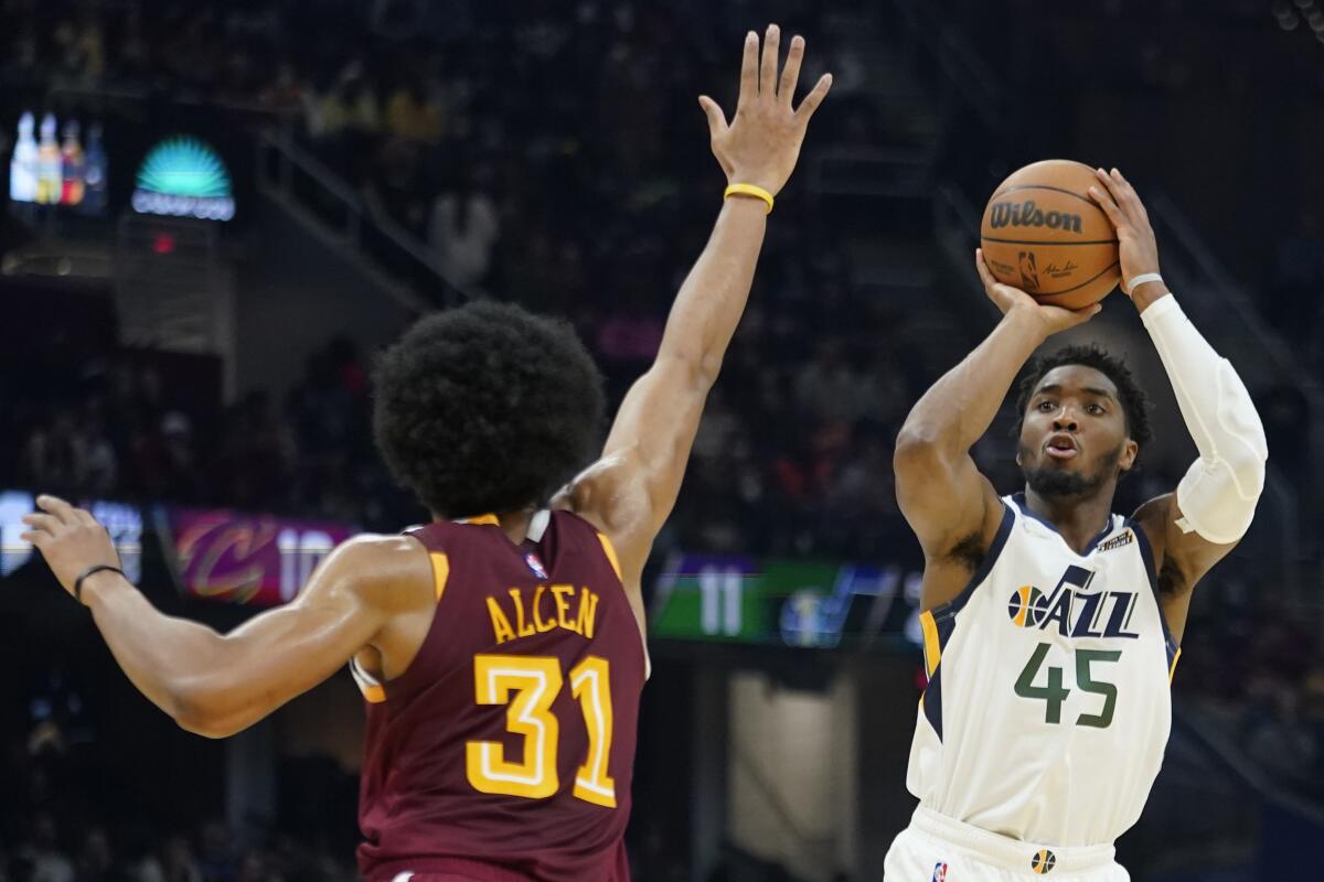 Utah Jazz's Donovan Mitchell (45) shoots over Cleveland Cavaliers' Jarrett Allen (31) in the first half of an NBA basketball game, Sunday, Dec. 5, 2021, in Cleveland. (AP Photo/Tony Dejak)