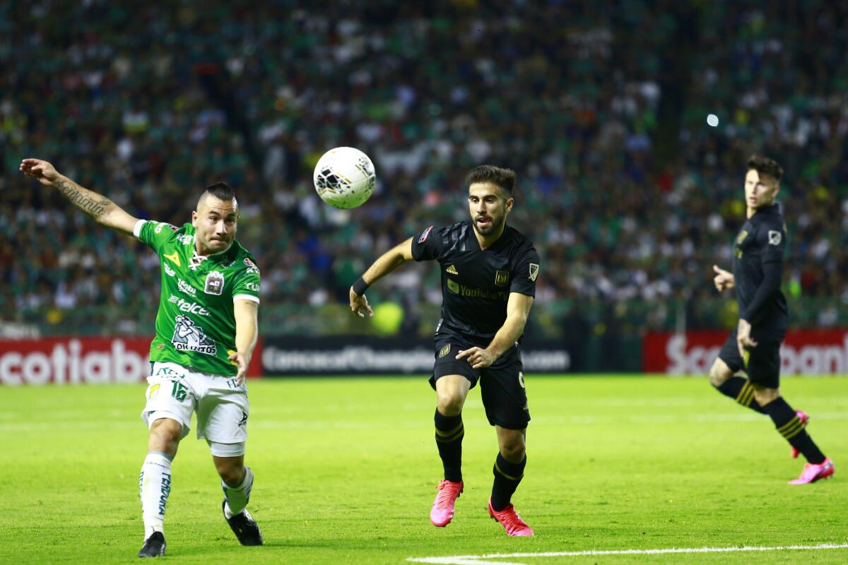 León's David Meneses, left, struggles for the ball with LAFC's Diego Rossi during the round of 16 match of the CONCACAF Champions League 2020 at Leon Stadium on Feb. 18 in León, Mexico.