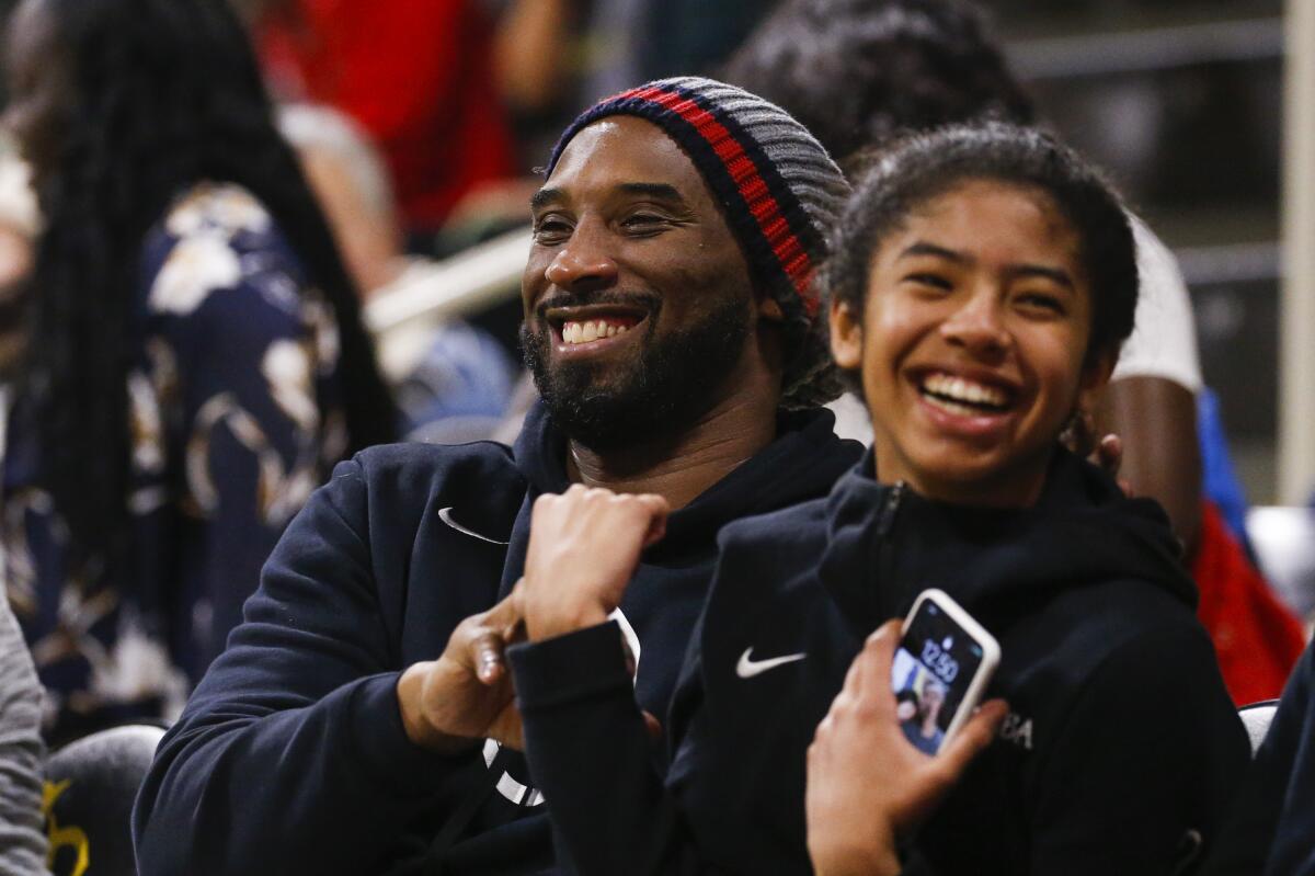 Kobe Bryant shares a laugh with his daughter Gianna at a women's basketball game between Long Beach State and Oregon on Dec. 14.
