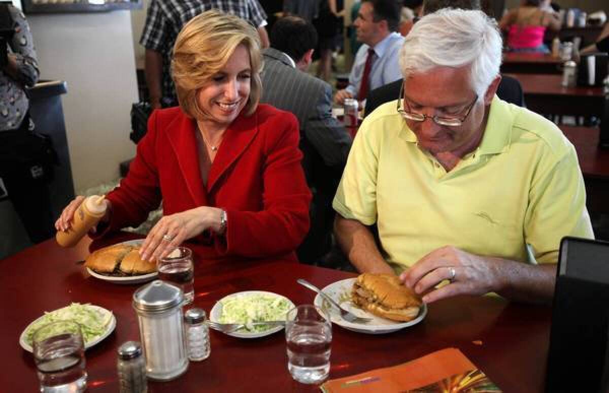 Wendy Greuel, shown with husband Dean Schramm while on the mayoral campaign trail, is enjoying a rare month off between losing to Eric Garcetti and leaving her controller's job, and deciding on her next move.