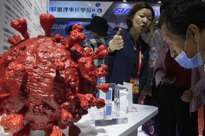 An employee fields questions about a new COVID-19 vaccine during a trade fair in Beijing last week.