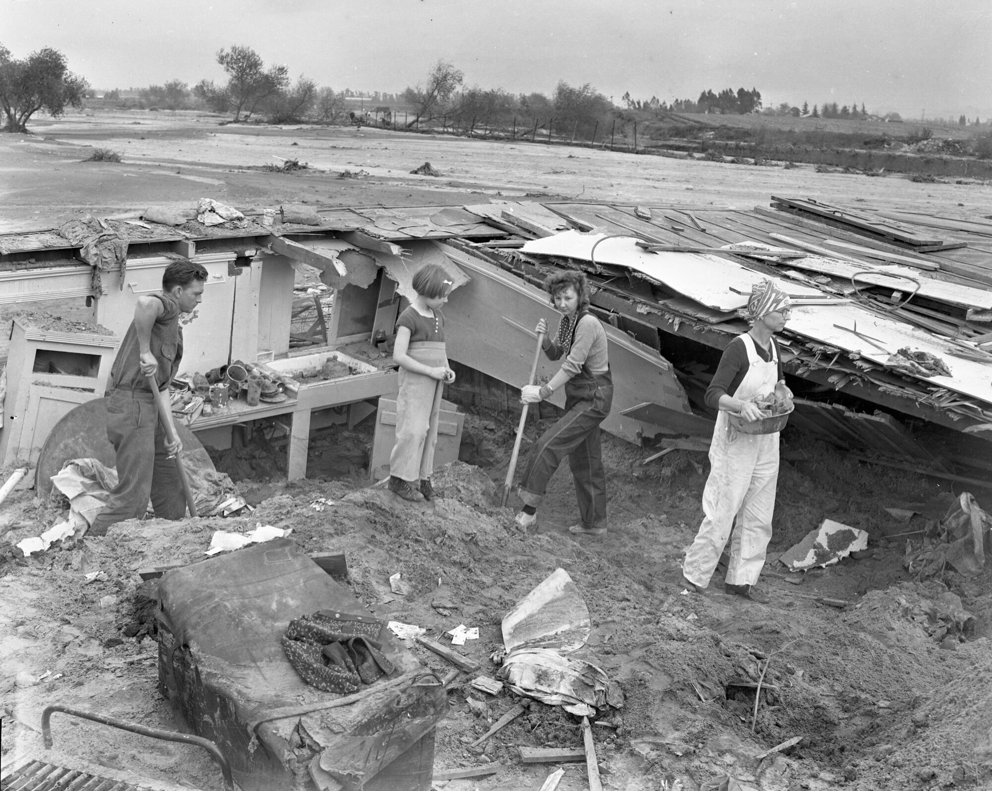 March 7, 1938: Mr. and Mrs. J. L. Smith, their daughter and 5-year-old granddaughter dig out a flood-ruined home in Van Nuys.