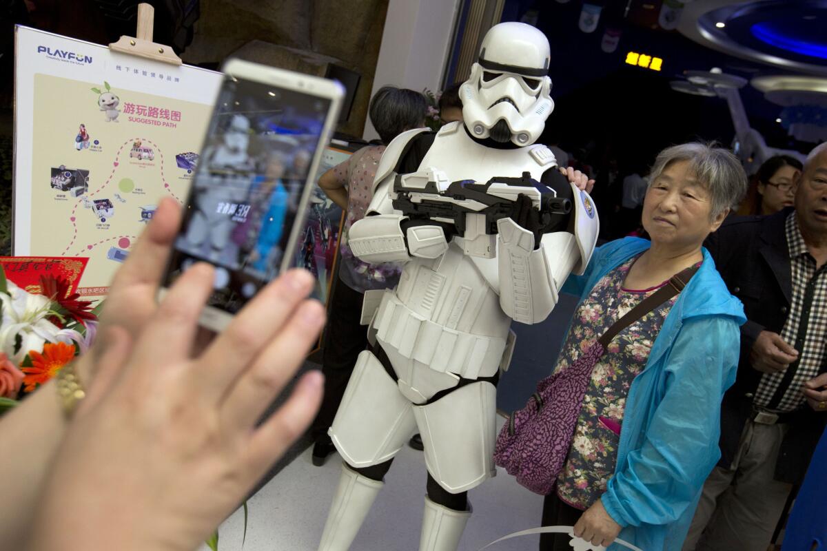 A Chinese woman poses with a worker dressed in a Star Wars storm trooper costume at the Wanda Mall at the Wanda Cultural Tourism City in Nanchang.