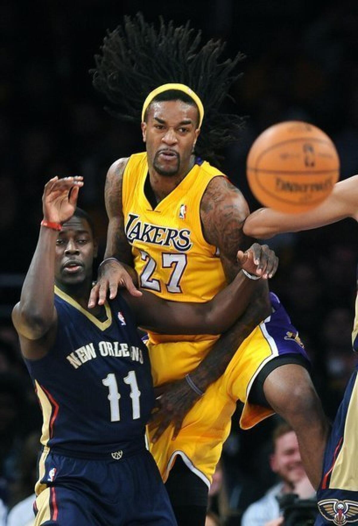 Lakers big man Jordan Hill (27) leans on New Orleans' Jrue Holiday during the Lakers' 116-95 win over the Pelicans at Staples Center on Tuesday.