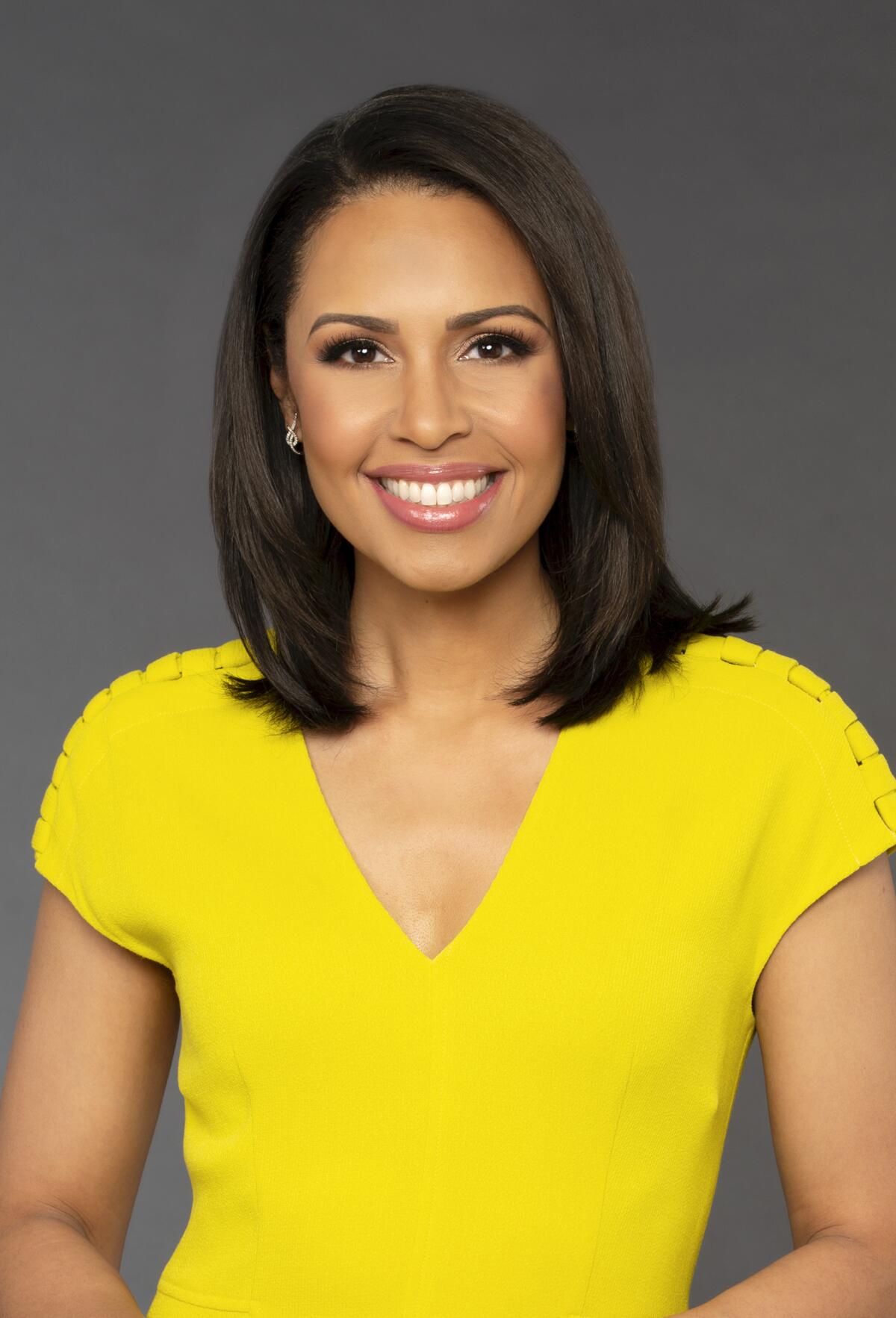 Portrait of Adrienne Bankert in a bright yellow dress.