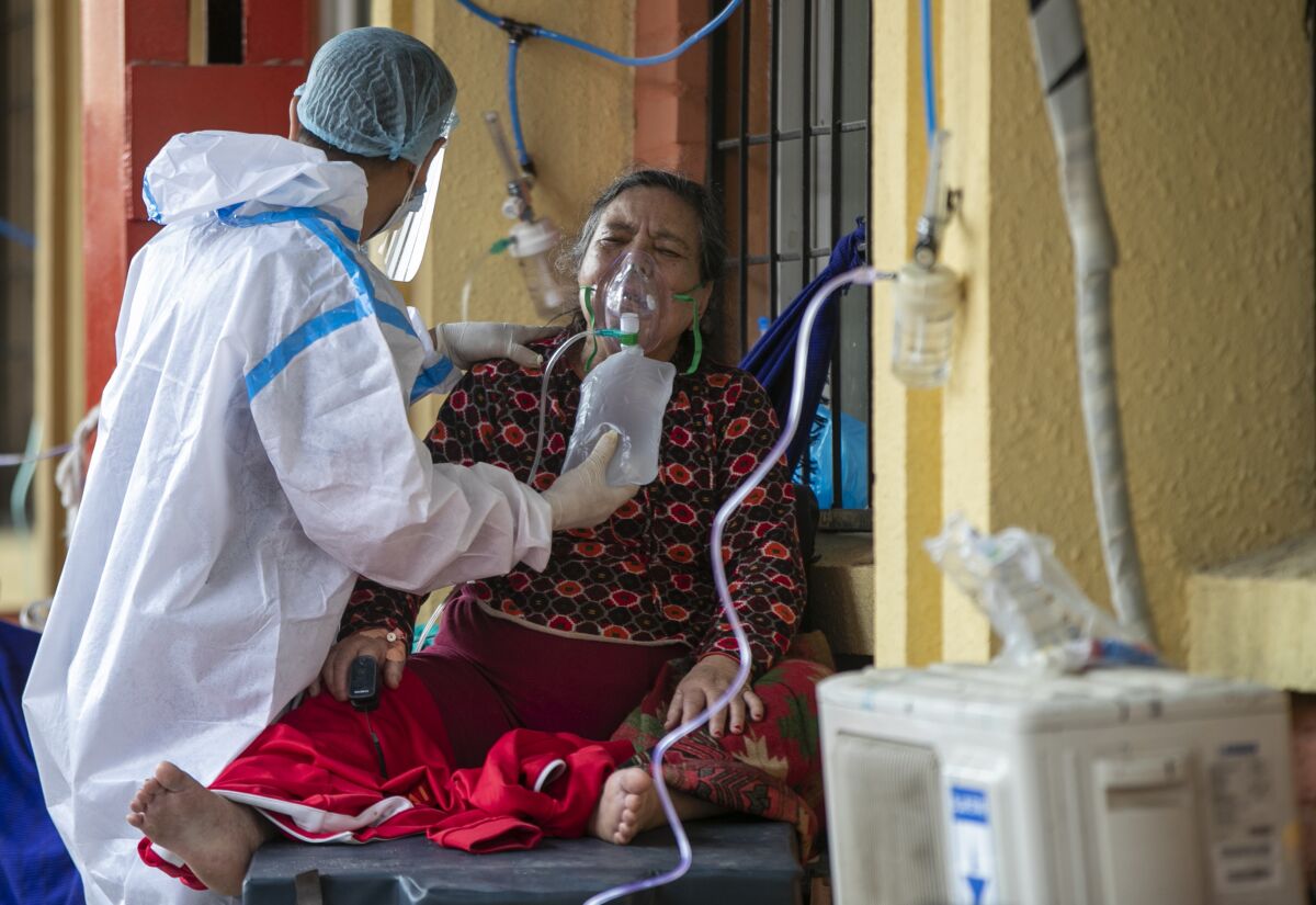 A paramedic attends to a COVID-19 patient outside an emergency ward of a government run hospital in Kathmandu, Nepal, Wednesday, May 12, 2021. (AP Photo/Niranjan Shrestha)