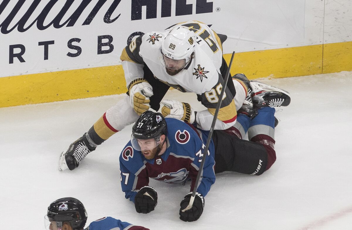 Colorado Avalanche's J.T. Compher (37) is checked by Vegas Golden Knights' Alex Tuch (89) during first period NHL hockey qualifying round game in Edmonton, Alberta, Saturday, Aug. 8, 2020. (Jason Franson/The Canadian Press via AP)