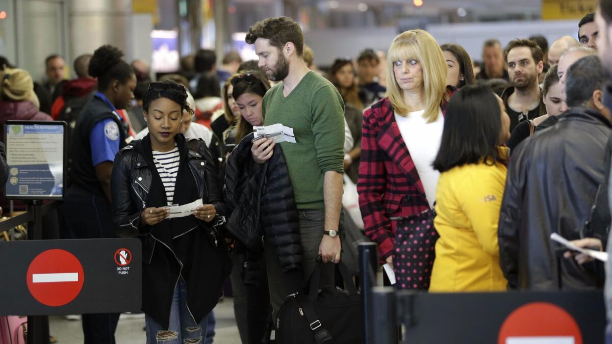 Passengers wait in line to clear security at LaGuardia Airport in New York on Nov. 25, 2015.