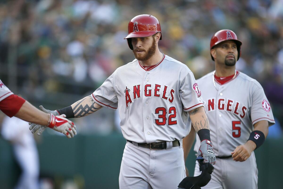 Josh Hamilton and Albert Pujols are congratulated after the outfielder's two-run home run in the third inning against the Oakland Athletics. Hamilton was 2 for 3 at the plate with three RBIs.