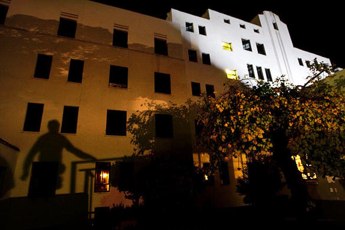 A crew member is silhouetted against the exterior of Linda Vista Community Hospital during a film shoot at the allegedly haunted site in Boyle Heights. The abandoned hospital, where railroad workers with tuberculosis once were cared for in furnished tents, has been used as a location for the movies "Outbreak," "End of Days" and "Pearl Harbor" and the pilot episode of the television show "ER."
