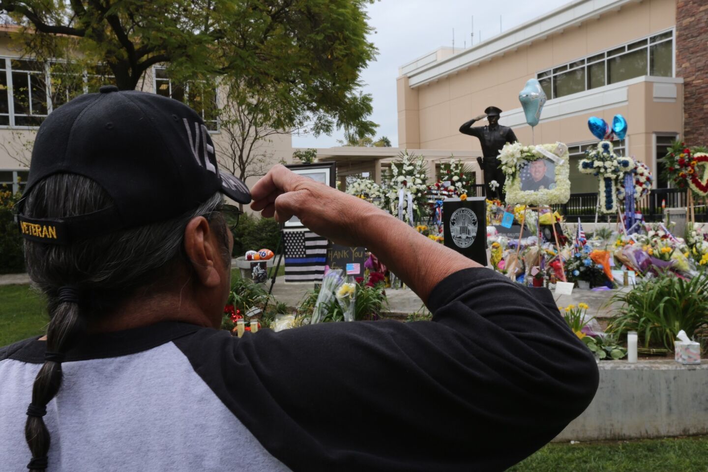 Vietnam veteran Frank Ventura salutes to pay his respects at the makeshift memorial for slain Whittier police officer Keith Boyer.
