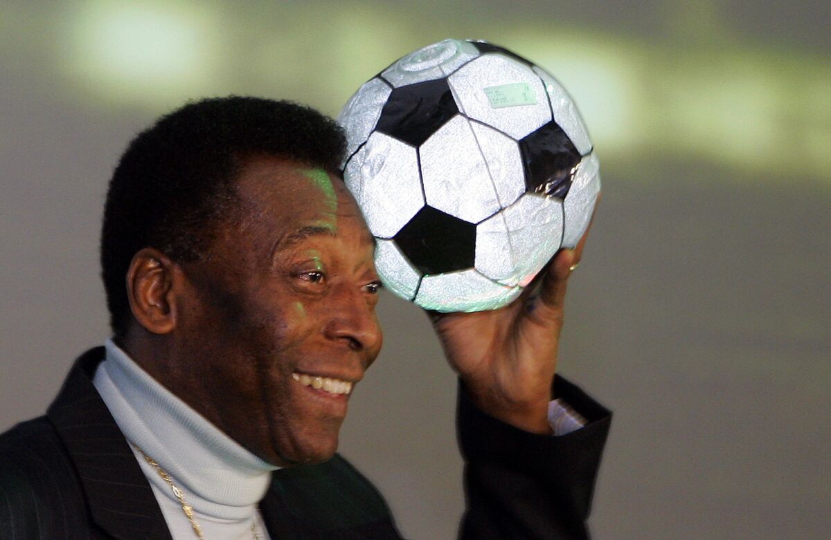 Brazilian soccer legend Pele poses for photographers with an inflatable soccer ball after a press conference for the exhibition "Pelestation - The Legend in Action" in Berlin, Wednesday, June 7, 2006. The exhibiton, which features many aspects of Pele's life as a soccer player, will open for the public Thursday.
