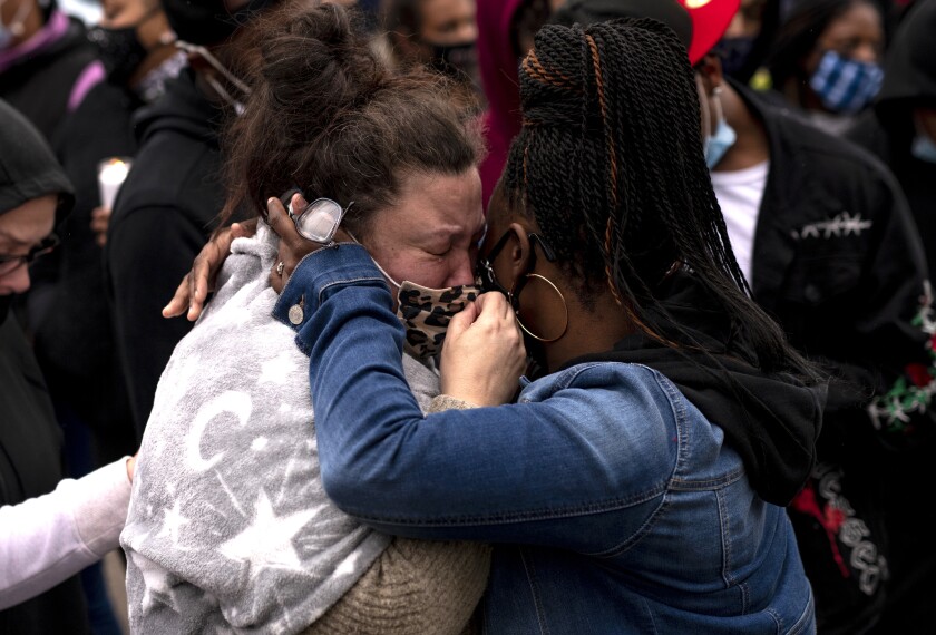 Katie Wright (L), the mother of Daunte Wright, is embraced during a vigil for her son 