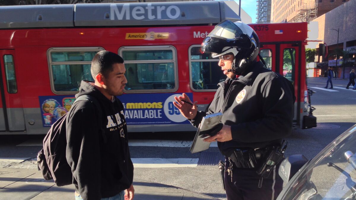 Eduardo Lopez receives a citation from LAPD motor officer Robert Lockhart in January 2015 for stepping into the intersection at Hope and 7th Street downtown after the red flashing hand and countdown timer has begun.