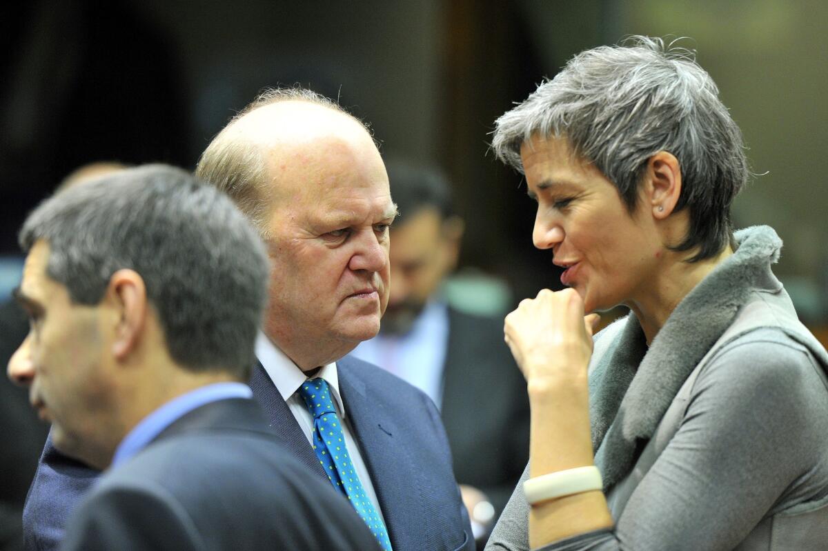 Irish Finance Minister Michael Noonan, center, and Danish Economy Minister Margrethe Vestager talk Tuesday before a meeting at European Union headquarters in Brussels.