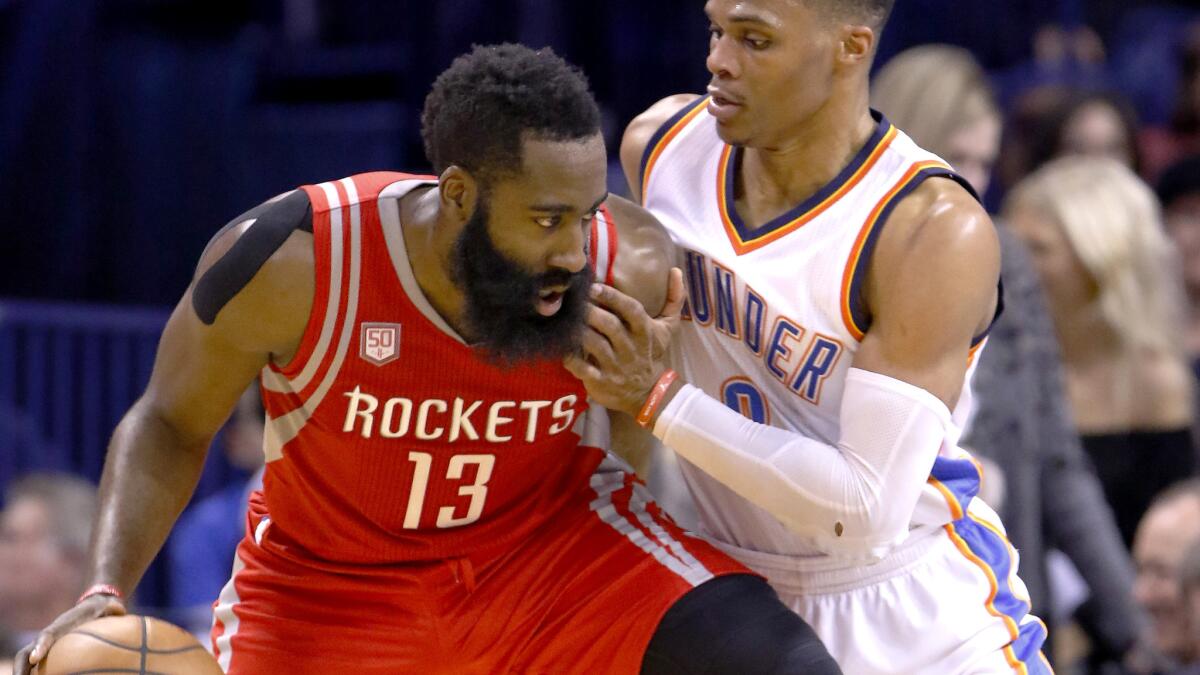 Rockets guard James Harden (13) tries to drives against Thunder guard Russell Westbrook during the second half Friday night.