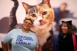 PASADENA, CA - AUGUST 3, 2024 - Left, Shannon Peace, 43, makes her message known, standing next to her friend Beverly Suzuki, 72, at CatCon held at the Pasadena Civic Auditorium in Pasadena on August 3, 2024. "He messed with the wrong demographic," said Peace about Sen. J.D. Vance's comment about "childless cat ladies." "You mess with the cat lady, you get the claws," she concluded. The event, often dubbed the comic con for cat lovers, will include cat celebrities, an art show and all things cat related. The event comes days after 2021 Fox News interview of Republican vice presidential nominee Sen. J.D. Vance's surfaced in which he complains that the country was being run by Democrats, corporate oligarchs and "a bunch of childless cat ladies who are miserable at their own lives and the choices that they've made and so they want to make the rest of the country miserable, too." (Genaro Molina/Los Angeles Times)
