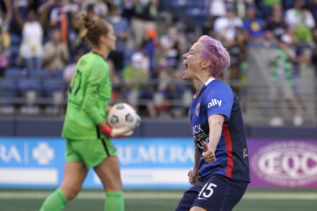 OL Reign forward Megan Rapinoe, right, celebrates as Portland Thorns goalkeeper Bella Bixby, left, holds the ball after Rapinoe scored a goal on a penalty kick during the first half of an NWSL soccer match, Sunday, Aug. 29, 2021, in Seattle. (AP Photo/Ted S. Warren)