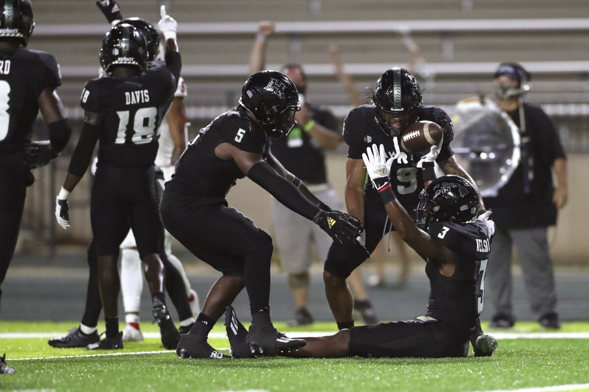 Hawaii defensive back Hugh Nelson II (3) reacts with defensive back Khoury Bethley (5) and defensive back Quentin Frazier (19) after Nelson made an interception against Fresno State during the fourth quarter of an NCAA college football game, Saturday, Oct. 2, 2021, in Honolulu. (AP Photo/Marco Garcia)
