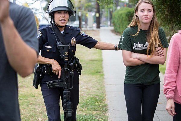A Santa Monica police officer ushers pedestrians away.