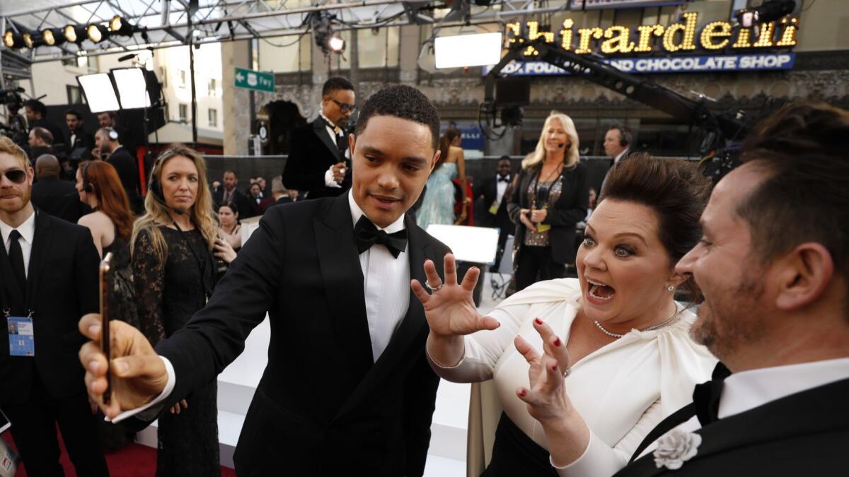Trevor Noah, left, Melissa McCarthy and husband Ben Falcone attend the 91st Academy Awards in Hollywood on Feb. 24.