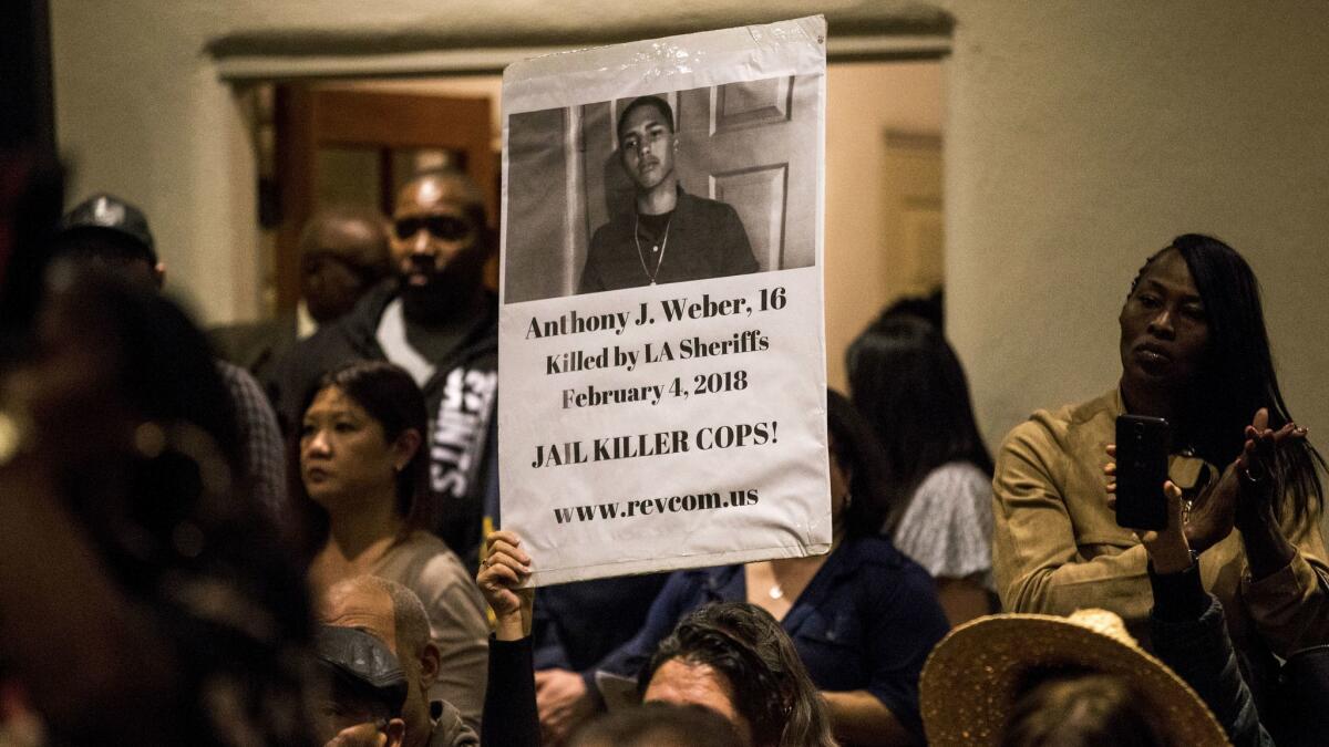 A photograph of slain 16-year-old Anthony Weber is held up during the emergency town hall meeting.