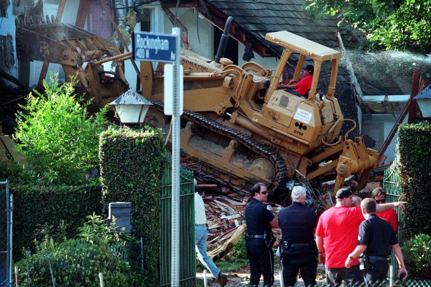 A bulldozer tears into the former home of O.J. Simpson in Brentwood in 1998.