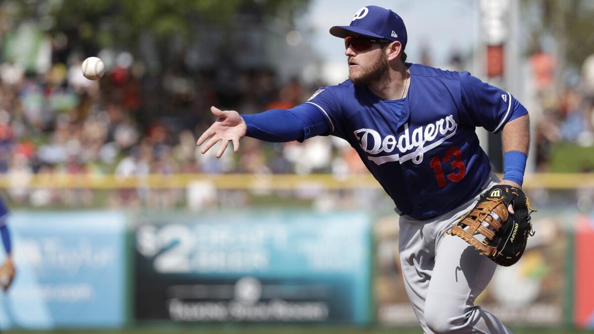 Dodgers first baseman Max Muncy tosses the ball during a spring training game against the San Francisco Giants on March 4.