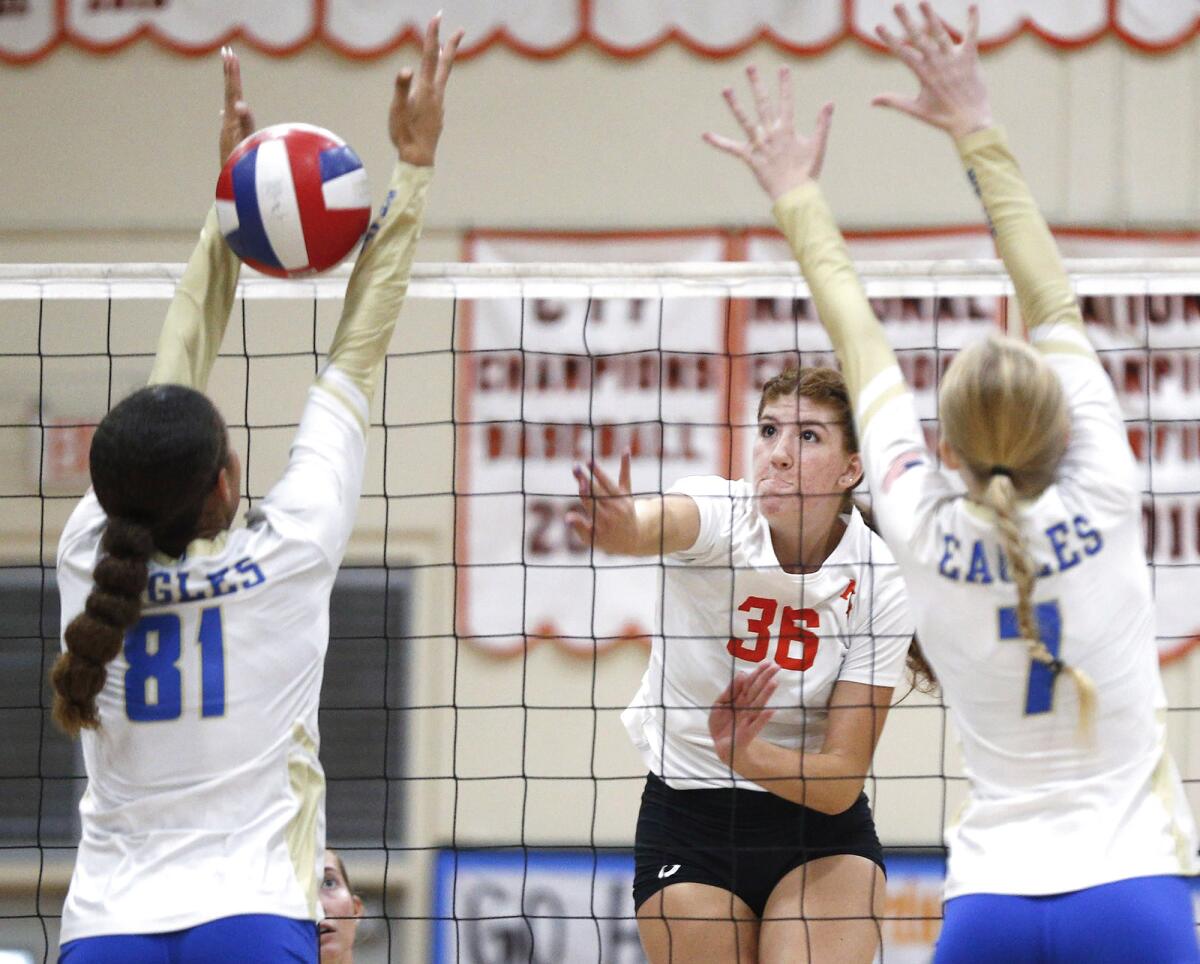 Kylie Leopard (36) of Huntington Beach kills a ball past the block of Santa Margarita's Memphis Burnett (81) on Tuesday.