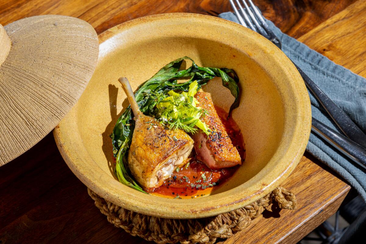 A bowl with confit duck leg and greens